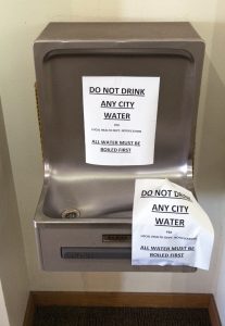 Photo of drinking fountain with "Do Not Drink Any City Water" sign