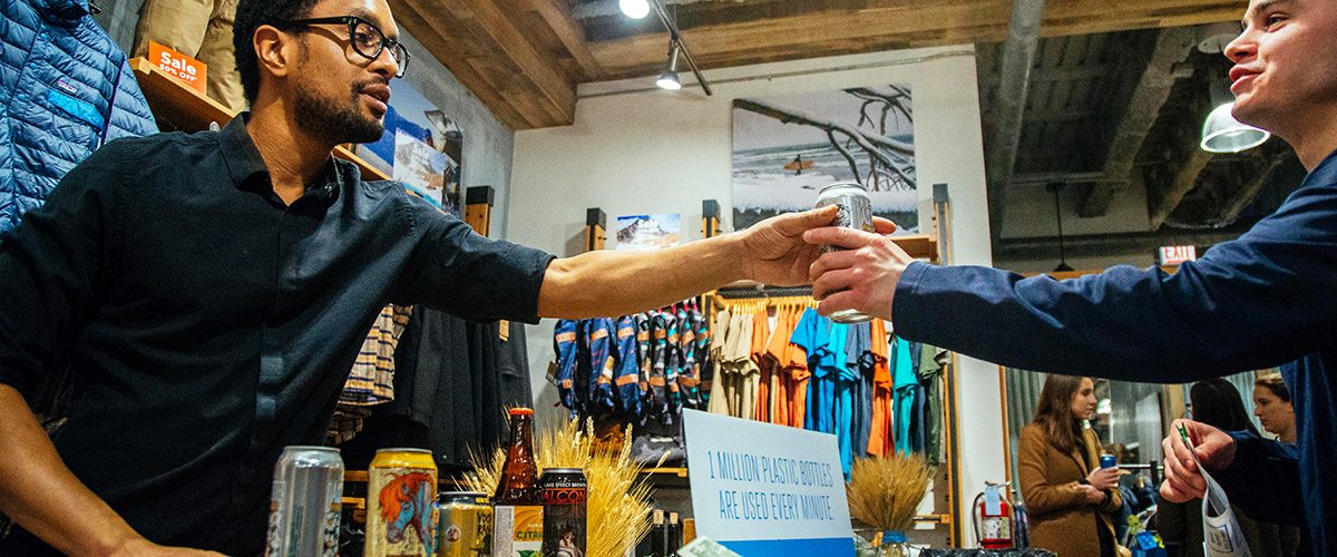 Bartender hands party-goer a drink at Libations for the Lakes.